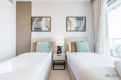 two beds in a room with a window at Delightful 2BR Apartment in VIDA Residences Dubai Marina by Deluxe Holiday Homes in Dubai