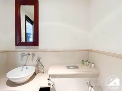 a bathroom with a white toilet and a mirror at Luxury 2Bedroom with Terrace & Burj Khalifa view in Dubai