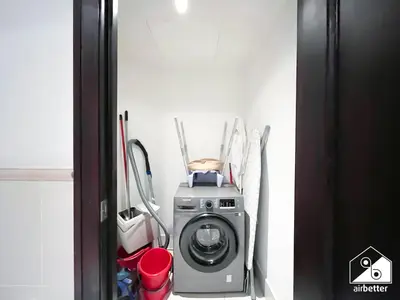 a washing machine in a corner of a room at Luxury 2Bedroom with Terrace & Burj Khalifa view in Dubai
