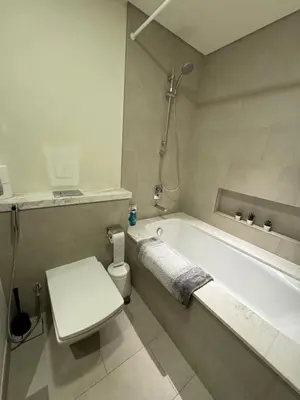 a white bathroom with a tub and a toilet at Guest Favourite! Beautiful 1 bedroom apartment in Dubai