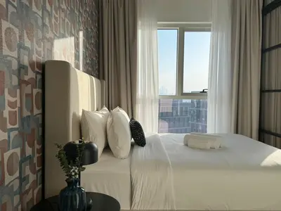 a bedroom with a white bed with a window at Oraya - Brand New 2BR Apt in Socio Tower at Dubai Hills in Dubai