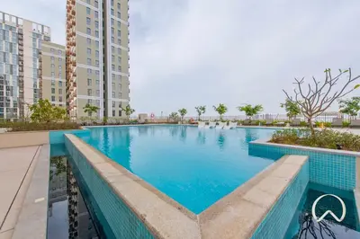 a swimming pool in a building with tall buildings at Oraya - Brand New 2BR Apt in Socio Tower at Dubai Hills in Dubai