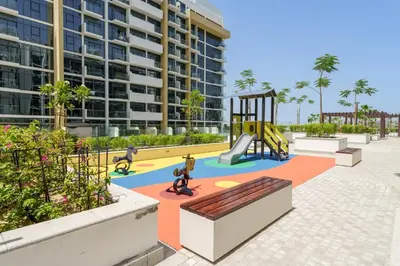 a playground in front of a building with a slide at Chic 1BR Apartment in Azizi Riviera, Meydan in Dubai