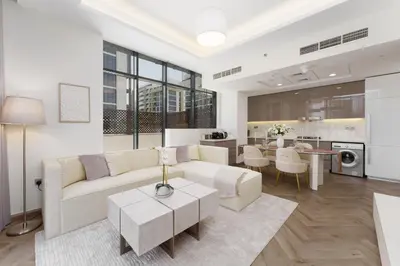 a living room with a couch and a table at Chic 1BR Apartment in Azizi Riviera, Meydan in Dubai