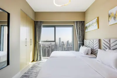 a hotel room with a bed and a large window at Livbnb - 3BR Deluxe suite w/ Burj Khalifa & Fountain Views in Dubai