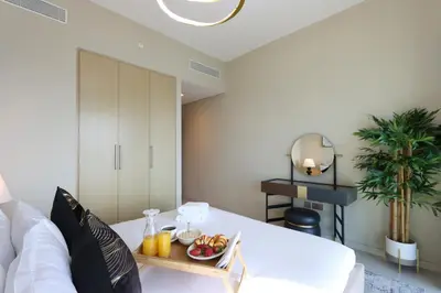 a living room with a white couch and a tray of fruit at Livbnb - 3BR Deluxe suite w/ Burj Khalifa & Fountain Views in Dubai