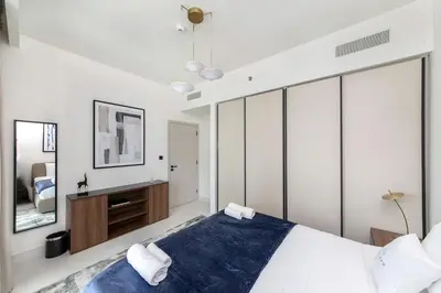 a bedroom with white walls and a large bed at Chic Apartments in Marina Vista Emaar Beachfront in Dubai