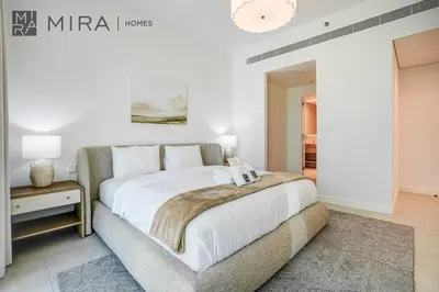 a bedroom with a large white bed and a table at Mira Holiday Homes - Luxury 2 bed apartment in La Vie in Dubai