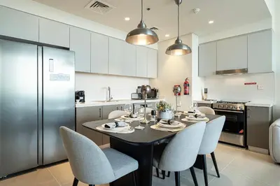 a kitchen with a table and chairs in a kitchen at Forte Tower - Downtown Dream, Ocean View, Opposite Dubai Mall in Dubai