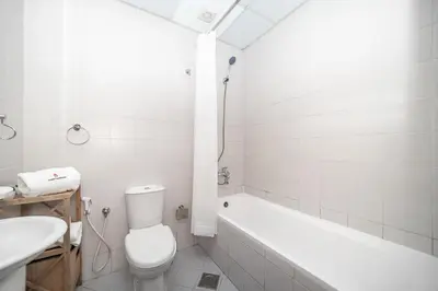 a bathroom with a toilet and a tub and a sink at StoneTree - Chic Studio - Near Beach in Dubai