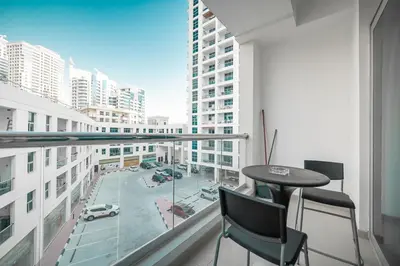 a balcony with a table and chairs and a view of a city at StoneTree - Chic Studio - Near Beach in Dubai