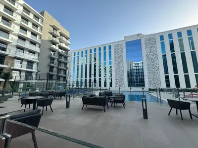 a patio with tables and chairs in front of a building at ASHRI HH, STANDARD STUDIO IN STUDIO CITY in Dubai
