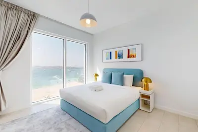 a bedroom with a large bed and a large window at La Vie JBR - Breathtaking Two Bedroom in Dubai