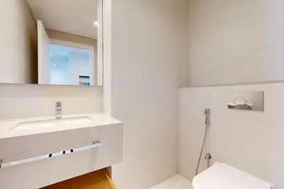 a white bathroom with a sink and a mirror at La Vie JBR - Breathtaking Two Bedroom in Dubai