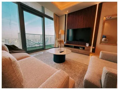 a living room with a couch and a tv and a table at Spectacular views on high floor with Infinity Pool in Dubai