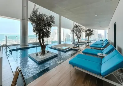 a group of blue chairs in a room with a pool at Spectacular views on high floor with Infinity Pool in Dubai
