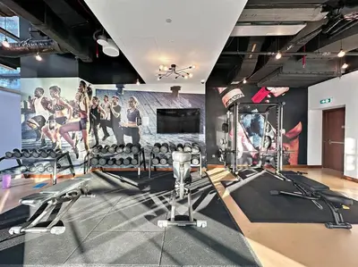 a gym with treadmills and a wall with a mural at Luxury 2BR with Marina Views Near Dining Shopping Attractions & Beaches in Dubai