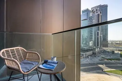 a chair sitting on a balcony with a view of a city at Modern Studio Downtown DT1, Walk to Dubai Mall, Burj View & Metro in Dubai