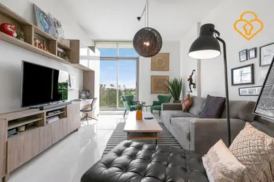 a living room with a couch and a tv at Keysplease 1 BR Polo Residence, Meydan in Dubai