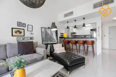 a living room with a couch and a kitchen at Keysplease 1 BR Polo Residence, Meydan in Dubai