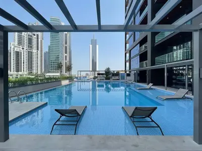 a large swimming pool with two chairs in a building at FIRST CLASS Studio Stylish Urban Escape in Dubai