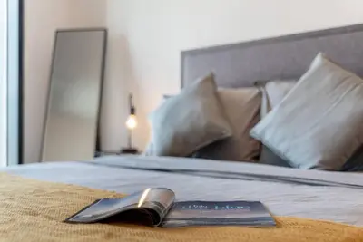 a book laying on top of a bed with pillows at FIRST CLASS Studio Stylish Urban Escape in Dubai