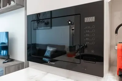 a black microwave oven in a kitchen at Nice apartment in JVC - Dubai in Dubai