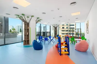 an office with colorful chairs and tables and windows at Nice apartment in JVC - Dubai in Dubai
