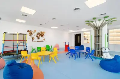 a room with colorful chairs and tables and a playground at Nice apartment in JVC - Dubai in Dubai