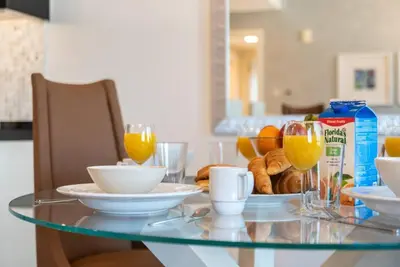 a glass table with a plate of food and glasses of orange juice at FIRST CLASS 2BR Modern Downtown Retreat in Dubai