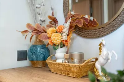 a table with a basket of flowers and a mirror at 1 bedroom - 12 min from downtown - Azizi Riviera in Dubai