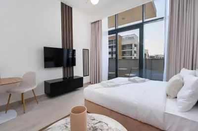 a bedroom with a white bed and a large window at Studio - 12 min downtown - Pool - Azizi Riviera in Dubai