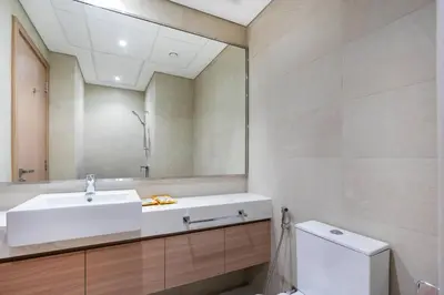 a bathroom with a sink and a mirror and a toilet at Studio - 12 min downtown - Pool - Azizi Riviera in Dubai