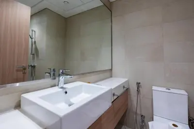 a bathroom with a white sink and a toilet at Studio - 12 min downtown - Pool - Azizi Riviera in Dubai