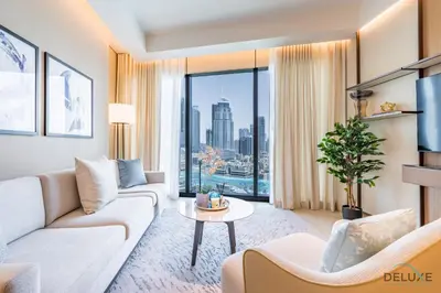 a living room with a couch and a large window at Elegant 2BR Apartment at The Address Residences Dubai Opera, Downtown Dubai by Deluxe Holiday Homes in Dubai
