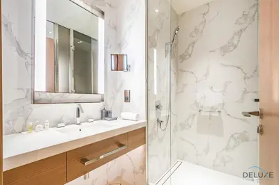 a bathroom with a sink and a shower with a mirror at Elegant 2BR Apartment at The Address Residences Dubai Opera, Downtown Dubai by Deluxe Holiday Homes in Dubai