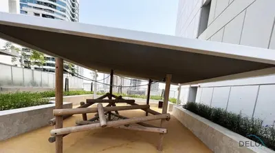 a group of picnic tables on a balcony of a building at Calm 1BR in Vera Tower, Business Bay by Deluxe Holiday Homes in Dubai