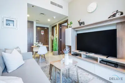 a living room with a large flat screen tv at Calm 1BR in Vera Tower, Business Bay by Deluxe Holiday Homes in Dubai