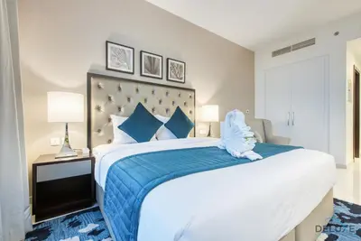 a bedroom with a large bed with a blue blanket at Charming Studio in Celestia A, Dubai South by Deluxe Holiday Homes in Dubai