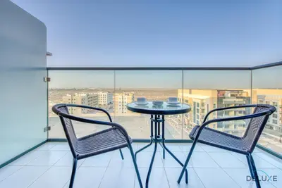a table and two chairs on a balcony with a view at Charming Studio in Celestia A, Dubai South by Deluxe Holiday Homes in Dubai