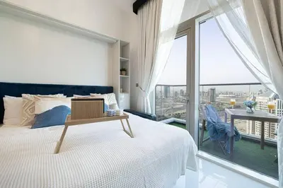a bedroom with a bed and a large window at Nice studio in Arjan - Dubai in Dubai