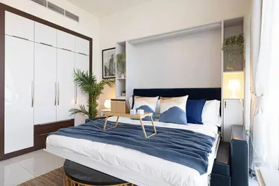 a bedroom with a large bed with a table on it at Studio - Miraclz Tower in Arjan in Dubai