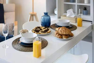 a table with plates of food and glasses of orange juice at Studio - Miraclz Tower in Arjan in Dubai