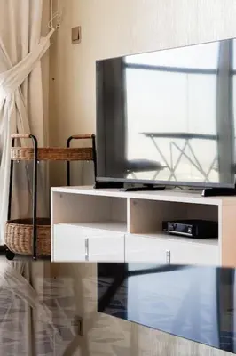 a flat screen tv sitting on top of a white entertainment center at Comfy Studio in Business Bay l Stays 2 in Dubai
