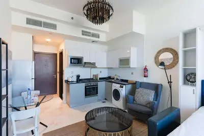 a kitchen and living room with a couch and a table at Comfy Studio in Business Bay l Stays 2 in Dubai