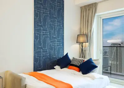 a bedroom with a bed with blue and orange pillows at Luxe Sea View High Floor 1 BR in Dubai Marina by Maxx Value Homes in Dubai