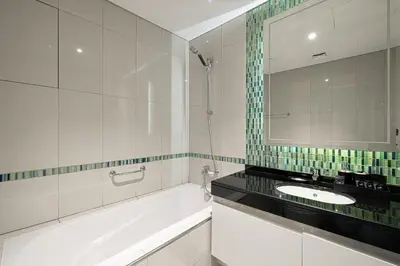 a bathroom with a tub and a sink and a mirror at Luxe Sea View High Floor 1 BR in Dubai Marina by Maxx Value Homes in Dubai