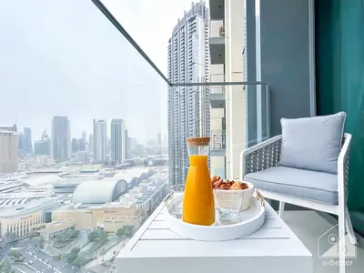 a table with a drink and a bowl of food on a balcony at Prestigious Burj Royale luxury Apartments Downtown in Dubai