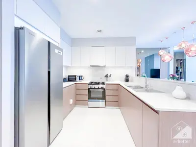 a kitchen with white cabinets and a stainless steel refrigerator at Prestigious Burj Royale luxury Apartments Downtown in Dubai