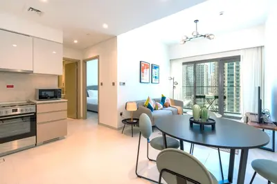 a kitchen and living room with a table and a couch at Prestigious Burj Royale luxury Apartments Downtown in Dubai